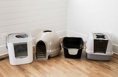 three different types of litter boxes sitting on the floor in front of a white wall