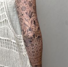 a woman's arm with flowers on it and an intricate lace border around the arm