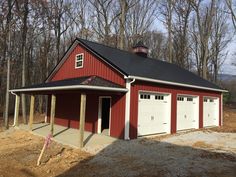 a red barn with two garages in front of it