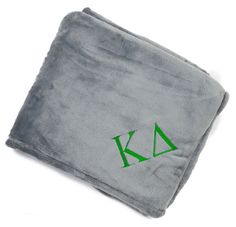 a gray towel with green letters on it and a black logo in the middle that says k