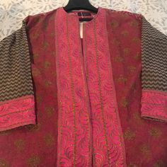 a red and brown jacket on a mannequin's neckline with an intricate design