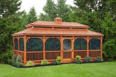 a wooden gazebo sitting on top of a lush green field