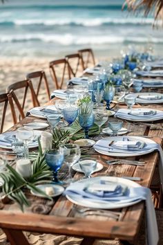 a long table set up on the beach with blue and white plates