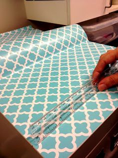 a person is using scissors to cut fabric on a sewing machine in a room with other items