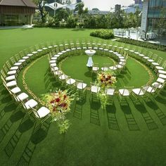 a circular lawn with chairs and flowers in the center