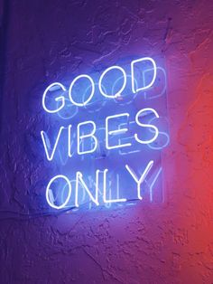 a neon sign that says good vibes only on the side of a purple wall