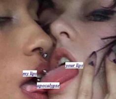 a close up of two people kissing each other with their noses covered in piercings