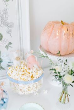 a table topped with plates and bowls filled with food next to a vase full of flowers