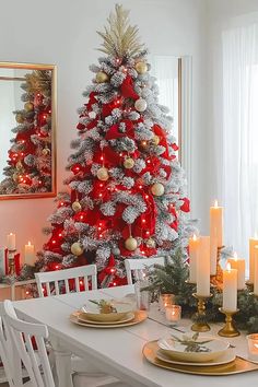 a christmas tree decorated with red, gold and silver ornaments is in the corner of this dining room