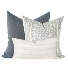 three pillows with different patterns on them, one in blue and the other in white