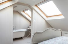 an attic bedroom with a bed and bathtub