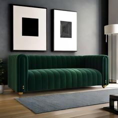 a living room with two framed pictures on the wall and a green couch in front of it