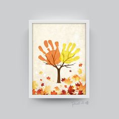 an orange and yellow hand print on a white frame with leaves around it in the shape of a tree