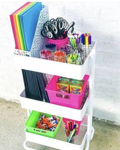 three tiered storage rack with pens, pencils, markers and other office supplies