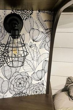 a lamp is on in front of a floral wallpaper