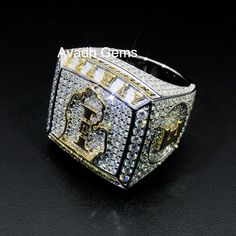 a large ring with the letter g on it's side and surrounded by diamonds