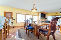 a dining room table with chairs and a ceiling fan in the middle of an open floor plan