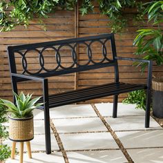 a black bench sitting next to a potted plant