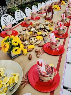 a long table covered with plates and bowls filled with lemons, cookies and other food