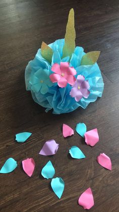 tissue paper flowers and petals on a wooden table with blue, pink, and green colors