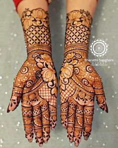 two hands with henna designs on them