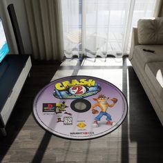 a video game disc sitting on the floor in front of a couch and television screen