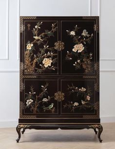 a black cabinet with flowers painted on it