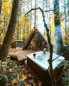 a person sitting in a hot tub surrounded by trees