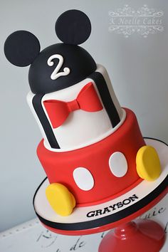 a mickey mouse birthday cake with the number two on top and a red bow tie