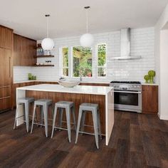 a kitchen with wooden flooring and white counter tops next to a stove top oven