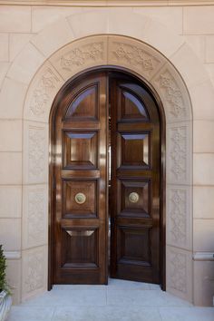 two wooden doors are open in front of a building