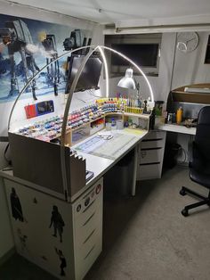 an office desk with lots of items on it and a large poster behind it that says star wars