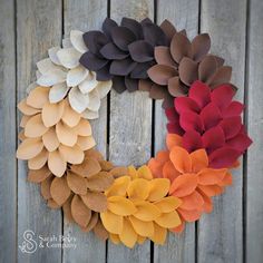 a wreath made out of felt flowers on a wooden surface