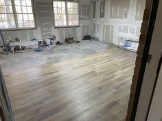 an unfinished room with hard wood floors and windows