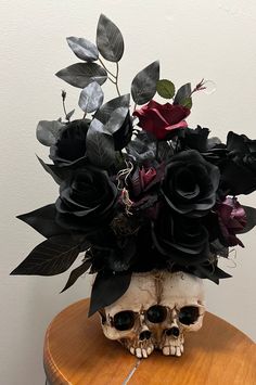 a skull with flowers in it sitting on top of a table