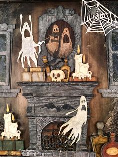 a fireplace decorated with halloween decorations and ghost figurines on top of the mantle