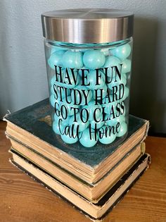 a glass jar filled with blue candy sitting on top of a stack of books