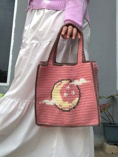 a woman holding a pink handbag with an image of a cat on the front