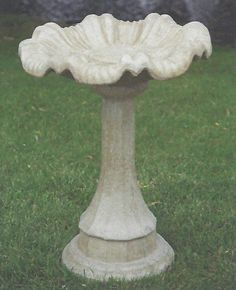 a bird bath sitting on top of a lush green field