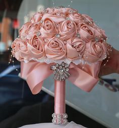 the bridal bouquet is adorned with pink roses