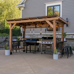 an outdoor kitchen with grill and seating area