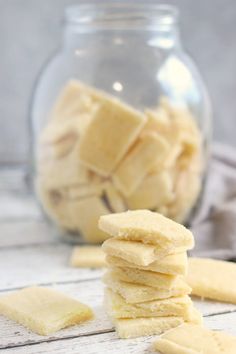 a stack of shortbreads sitting on top of a table next to a glass jar