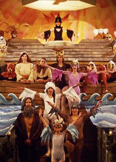 a group of people standing on top of a boat in front of a stage filled with clowns