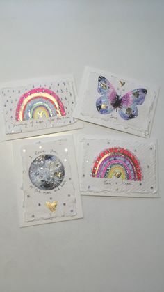 four small cards with butterflies and rainbows on them