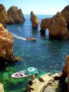 a boat is in the water near some rocks