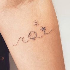 a woman's arm with a tattoo on it that has a flower and a palm tree