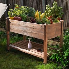 a wooden planter filled with lots of vegetables