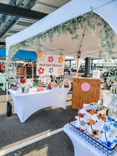 an outdoor market with many items for sale on the tables and in front of it is a sign that says happy birthday