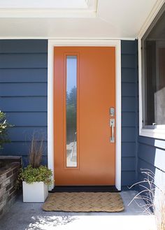 an orange front door on a blue house