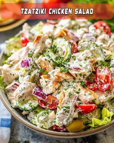 a close up of a salad in a bowl on a table with tomatoes and lettuce